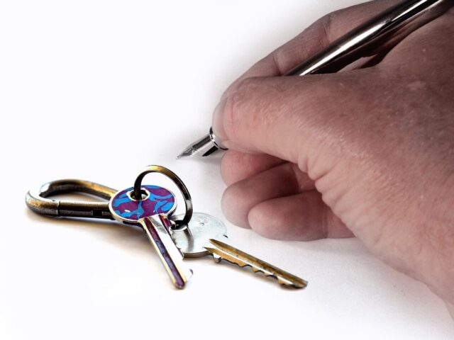 hand signing agreement and home keys